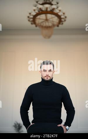 Bel homme tendance dans une tenue vestimentaire élégante sur un intérieur moderne classique. Luxe et style, concept de beauté masculine Banque D'Images