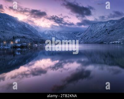 Vue aérienne du lac, montagnes enneigées, arbres, ciel violet la nuit Banque D'Images