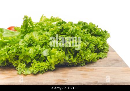 Feuilles de salade verte sur planche à découper en bois. Vue latérale. Préparation de la salade pour la collation. Banque D'Images