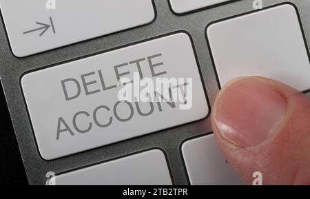 Un homme appuyant sur un bouton de suppression de compte sur un clavier de calcul. Banque D'Images