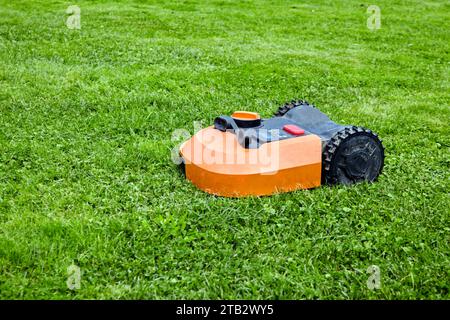 Robot tondeuse coupe l'herbe verte sur la pelouse. Banque D'Images