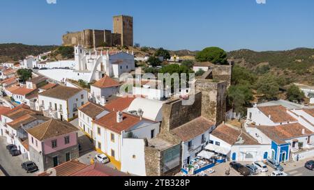 Château de Mértola au-dessus de la ville historique et église avec des maisons blanches le long de la vallée de la rivière Guadiana dans Alentejo Portugal vue sur la forteresse médiévale. Août 2022 Banque D'Images
