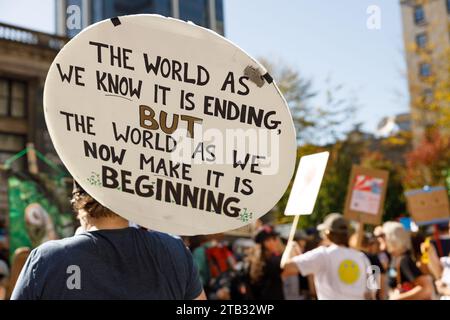 Vancouver, Canada - 15 septembre 2023 : activiste avec un signe : le monde tel que nous le connaissons se termine, mais le monde tel que nous le faisons maintenant commence comme partie O. Banque D'Images