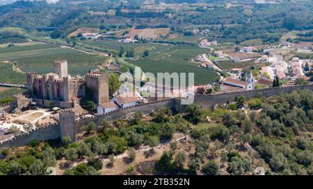 Óbidos murailles médiévales et château surplombant la ville blanche historique et le paysage de campagne dans le centre du Portugal site du patrimoine fortifié. Août 2022 Banque D'Images