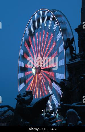 Leipzig, Allemagne. 04 décembre 2023. Une grande roue tourne au marché de Noël sur Augustusplatz, avec la fontaine Mendebrunnen au premier plan. Le marché peut être visité jusqu'au 23.12.2023. Crédit : Sebastian Willnow/dpa/Alamy Live News Banque D'Images