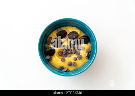 une image de fond de papier peint de bureau d'un bol d'acai à la mangue surmonté de pépites de chocolat et de biscuits. Banque D'Images