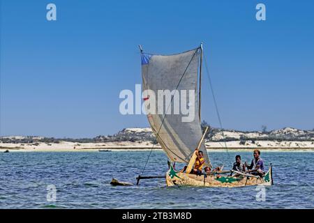 Pêcheurs malgaches naviguant en bateau de pêche traditionnel en bois / canoë à balancier sur l'océan Indien, Andavadoaka, région Atsimo-Andrefana, Madagascar Banque D'Images