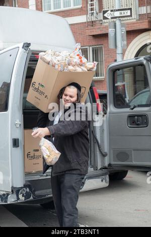 Un ouvrier juif orthodoxe livre du pain Franczoz dans un supermarché Glatt Kosher à Williamsburg, Brooklyn, New York. Banque D'Images