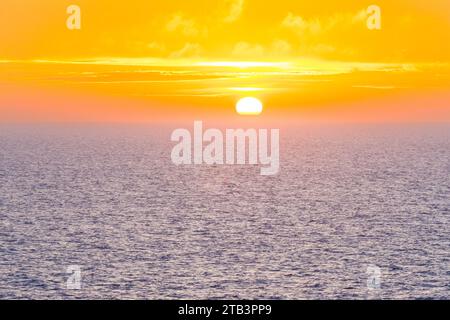 Magnifique coucher de soleil dans l'océan Atlantique avec ciel orange et océan bleu quelque part dans les îles Féroé Banque D'Images