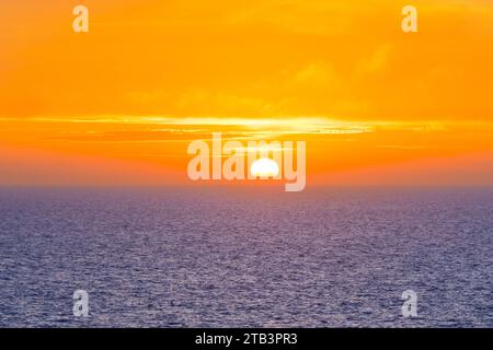 Magnifique coucher de soleil dans l'océan Atlantique avec ciel orange et océan bleu quelque part dans les îles Féroé Banque D'Images