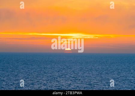 Magnifique coucher de soleil dans l'océan Atlantique avec ciel orange et océan bleu quelque part dans les îles Féroé Banque D'Images