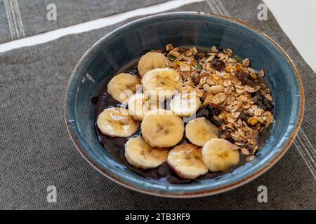 un bol de crème glacée acai saine garnie de banane avoine et de miel. Banque D'Images