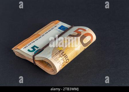 Paquet de 50 billets en euros sur une table sur fond noir gros plan. Banque D'Images