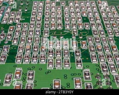 Carte de circuit imprimé verte avec de nombreux composants dessus. Mise au point sélective. Banque D'Images