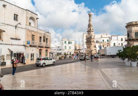 Ostuni, Pouilles, Italie - 5 octobre 2023 : la place centrale avec la colonne de Saint Oronzo dans le centre historique d'Ostuni. Banque D'Images