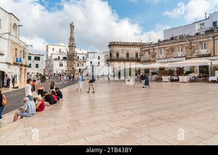 Ostuni, Pouilles, Italie - 5 octobre 2023 : la place centrale avec la colonne de Saint Oronzo dans le centre historique d'Ostuni. Banque D'Images