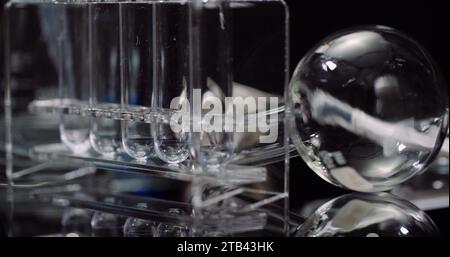 Equipement de laboratoire : seringue et médecine, tubes à essai et flacons tournant sur fond noir. Banque D'Images