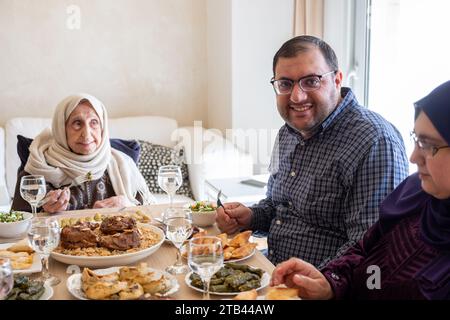 Famille arabe dînant ensemble sur une table en bois avec père, mère, grand-père, grand-mère et fils Banque D'Images