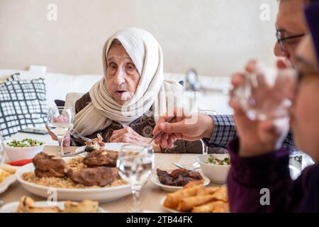 Famille manger avec des membres de plusieurs générations dans le salon moderne Banque D'Images