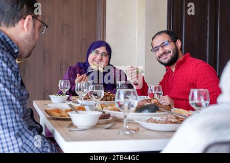 Famille manger avec des membres de plusieurs générations dans le salon moderne Banque D'Images