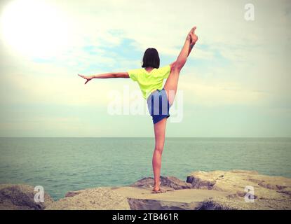 fille de derrière avec sa jambe vers le haut faisant de la gymnastique et effet de tons antiques Banque D'Images