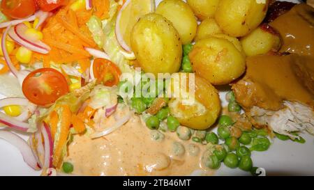 Une assiette de pommes de terre avec des pois et des salades saines Banque D'Images