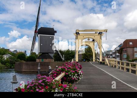 Moulin à vent historique de de Put et pont Rembrandt dans la rivière Rijn dans la ville de Leiden, aux pays-Bas, contre un ciel bleu nuageux blanc Banque D'Images