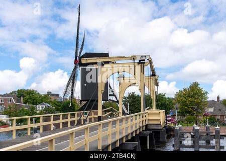 Moulin à vent historique de de Put et pont Rembrandt dans la rivière Rijn dans la ville de Leiden, aux pays-Bas, contre un ciel bleu nuageux blanc Banque D'Images