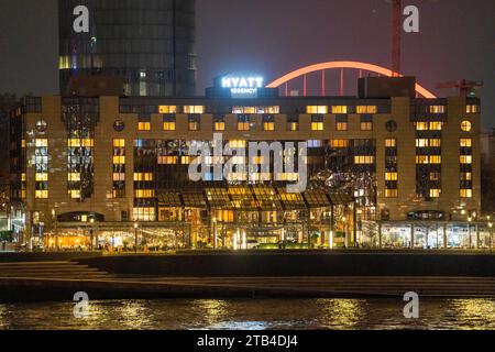 L'hôtel Hyatt Regency sur le Rhin, à Cologne Deutz, derrière lui l'arche illuminée de la Lanxess Arena, Rhin, NRW, Allemagne Banque D'Images