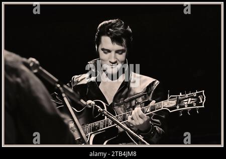 Elvis Presley avec guitare dans un show spécial comeback 1968, portant son costume en cuir emblématique sur scène Banque D'Images