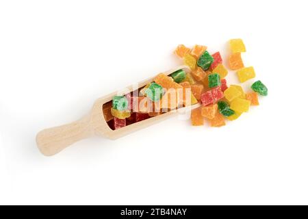 fruits confits coupés en dés dans une pelle en bois isolée sur blanc, écorce d'oranges, papayes et succade utilisés comme garniture en confiserie, pâtisserie ou comme additif i. Banque D'Images