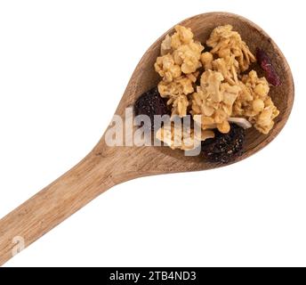 granola croquant dans une cuillère en bois isolé sur fond blanc avec chemin de coupe, pile de muesli avec des noix, canneberges et raisins secs près Banque D'Images