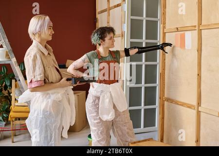 Deux jeunes femmes choisissant la couleur appropriée pour les murs de leur nouvel appartement Banque D'Images