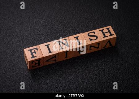 L'inscription se termine sur des cubes en bois sur un fond de béton foncé. Peut être utilisé dans le cadre de votre composition Banque D'Images