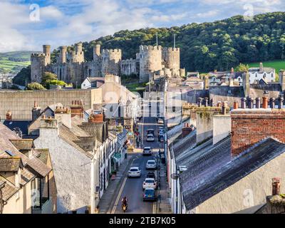 29 septembre 2023 : Conwy, pays de Galles du Nord, Royaume-Uni - Conwy Castle et Barry Street, avec la circulation et les gens. Banque D'Images