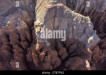 Une prise de vue aérienne capture les textures complexes des sommets imposants baignés par la lueur chaude d'un soleil couchant. Banque D'Images