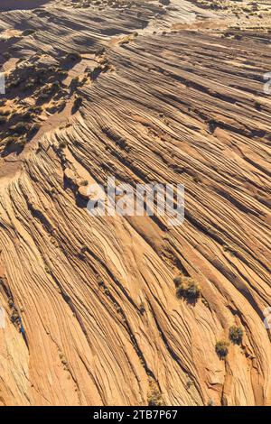 Prise de vue aérienne capturant les motifs complexes des strates rocheuses érodées dans un environnement désertique aride, présentant des teintes et des textures terreuses. Banque D'Images