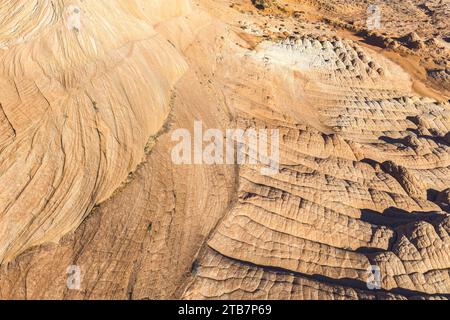 Une prise de vue aérienne capturant les motifs et textures complexes formés par l'érosion éolienne dans un paysage désertique sablonneux. Banque D'Images