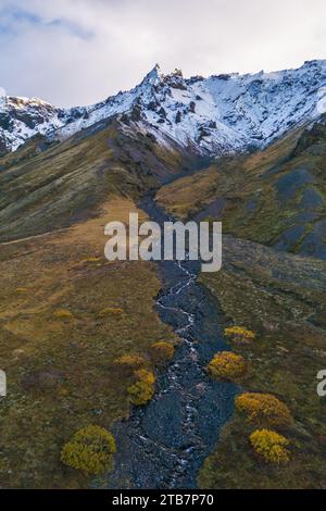 Prise de vue aérienne capturant le magnifique paysage de Thorsmork dans les Highlands d'Islande, avec des sommets enneigés et une rivière sinueuse. Banque D'Images