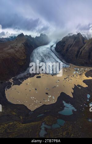 Captivante prise de vue aérienne montrant la beauté tentaculaire d'un glacier traversant le parc national de Vatnajokull en Islande, entouré de terres accidentées Banque D'Images