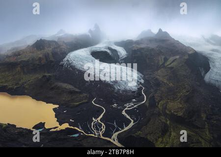 Captivante prise de vue aérienne montrant la beauté tentaculaire d'un glacier traversant le parc national de Vatnajokull en Islande, entouré de terres accidentées Banque D'Images