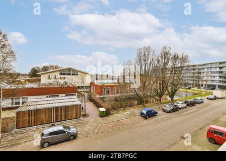 Vue aérienne des bâtiments résidentiels avec des voitures garées dans la rue dans la ville contre le ciel nuageux pendant la journée Banque D'Images