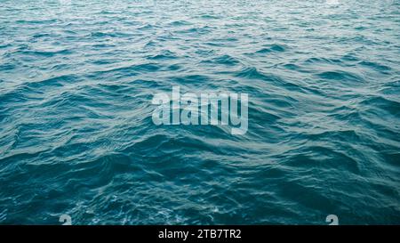 Un arrière-plan abstrait de l'écoulement de l'eau de mer sous exposition à la lumière. vague de mer en gros plan, vue à faible angle. Comme un arrière-plan. Les petites vagues créent des ondulations. Banque D'Images