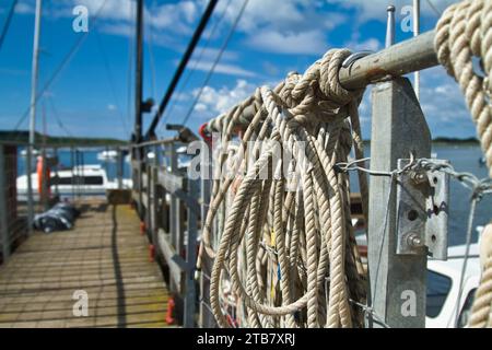 Cordes d'amarrage attachées à Une jetée de bateau menant à la mer, Christchurch Harbour, Royaume-Uni Banque D'Images