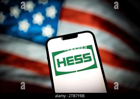 Le logo Hess est vu avec un drapeau américain en arrière-plan dans cette illustration photo le 13 mars 2023 à Varsovie, Pologne. Banque D'Images