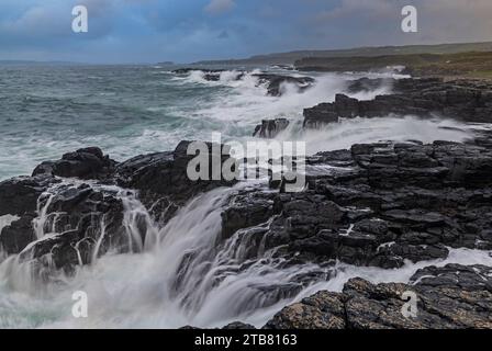 Vagues s'écrasant sur le rivage rocheux à Dunseverick sur la Causeway Coast, Irlande du Nord, Royaume-Uni. Automne (novembre) 2022. Banque D'Images