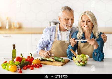 Hobbies de retraite. Heureux conjoints seniors faisant du contenu pour Food Blog Banque D'Images
