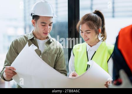 Ingénieurs civils et architectes inspectant et travaillant le site de construction avec des plans Banque D'Images