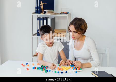 Un garçon avec un enseignant est engagé dans le développement de l'apprentissage en classe Banque D'Images