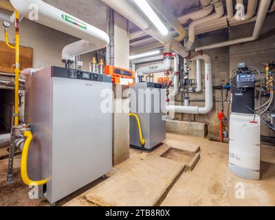 Chaufferie dans le sous-sol d'un nouveau bâtiment, un logement public blocs d'appartements. Chaudière Viessmann, adoucisseur d'eau BWT et tuyaux du circuit primaire Banque D'Images